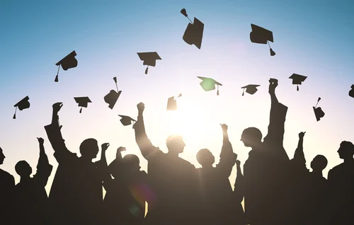 Group of graduates throwing their caps in the air at the same time