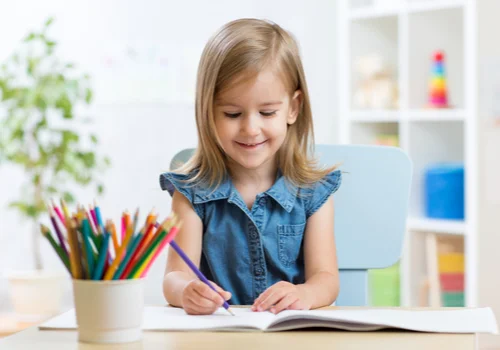 a little girl coloring on her coloring book