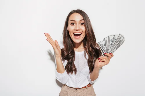 woman with excited face holding multiple dollar bills