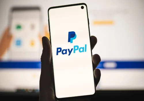 A person hold a phone with the pay pal open 