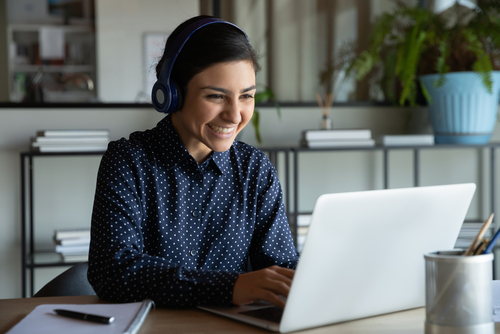 woman with headphones typing on computer