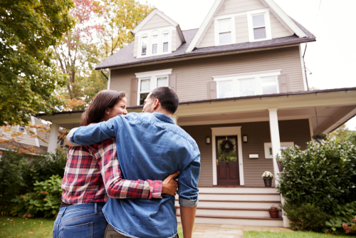 man and woman hugging and about to walk up stairs to their home