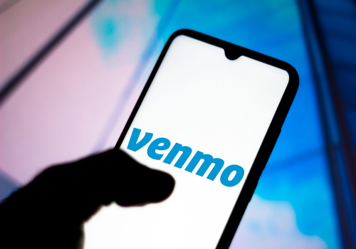 A person holding their smart phone with the Venmo app open. 