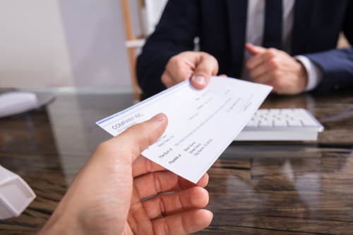 person handing over signed check