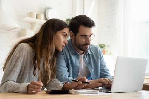 man and woman looking intently at computer screen