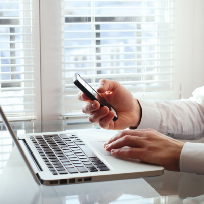 A Person on their phone and laptop