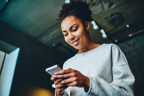 woman smiling down at phone