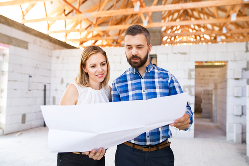 Couple looking at blueprint for their new home construction project.