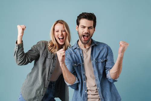 man and woman excited with fists in the air