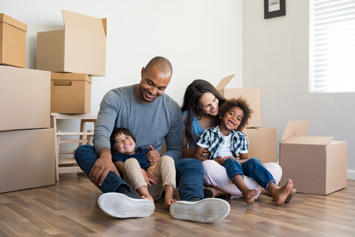 family sitting on the floor in their new house