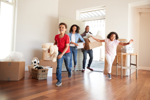 family entering house carrying boxes