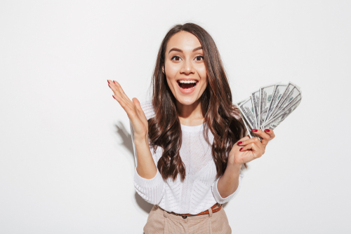 woman with excited face holding multiple dollar bills