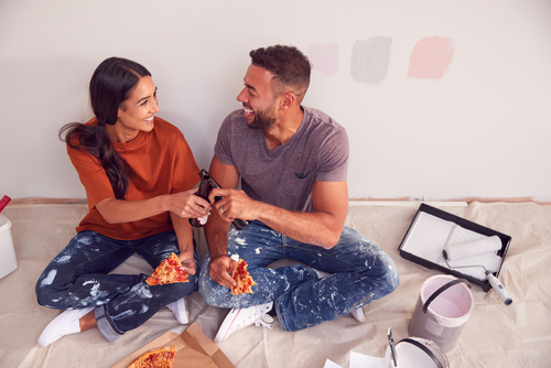 man and woman sitting on the floor taking a break from painting their house