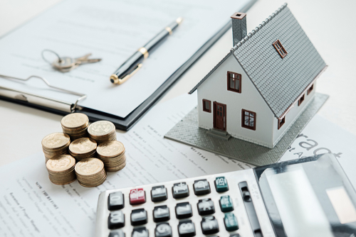 calculator stack of coins and miniature house