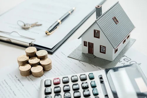 calculator stack of coins and miniature house