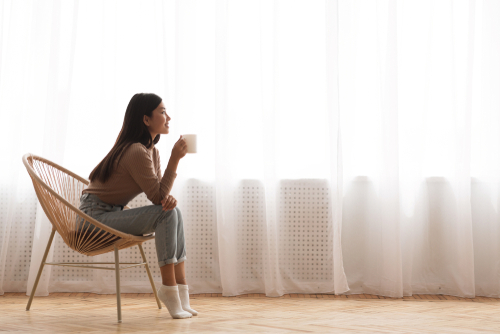 woman sitting in chair drinking coffee