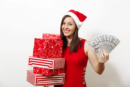 A girl holding cash and presents for Christmas