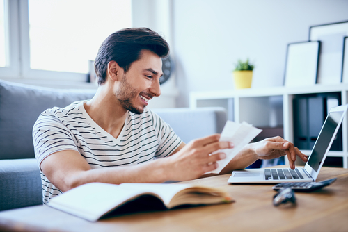 man smiling and looking at computer screen