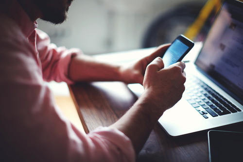 person using phone and computer