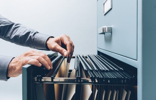 person opening up a filing cabinet