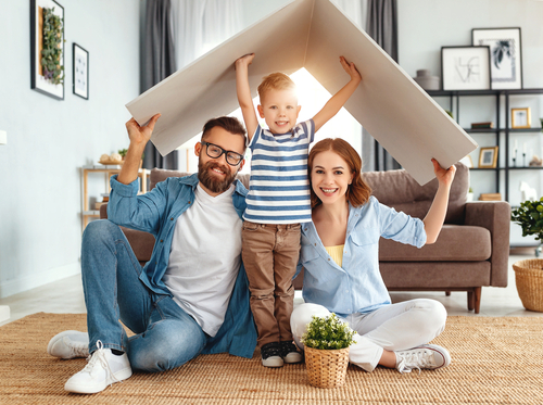 family sitting in living room smiling and playing