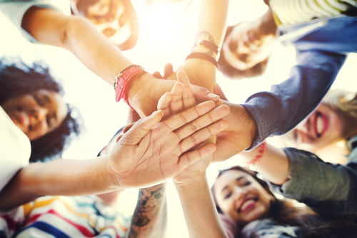 group of people with hands in middle