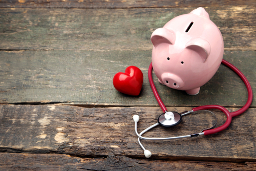 medical stethoscope and piggy bank 